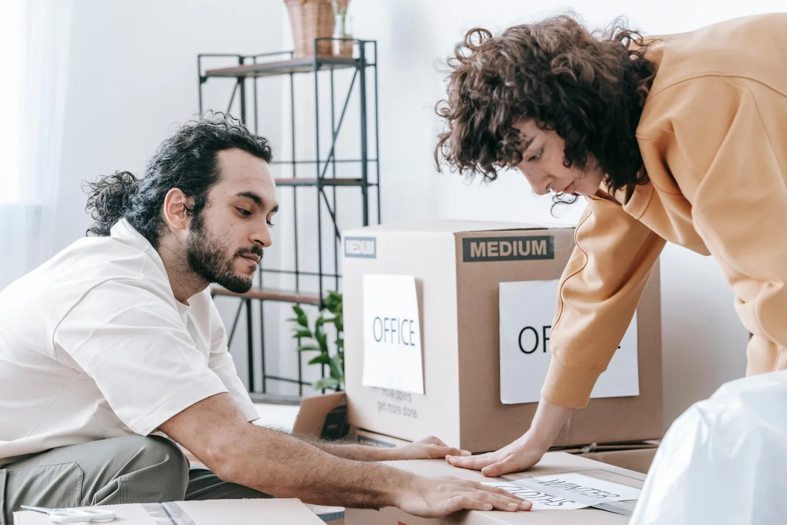 موظفون يجهزون صناديق نقل المكتب بلافتة OFFICE